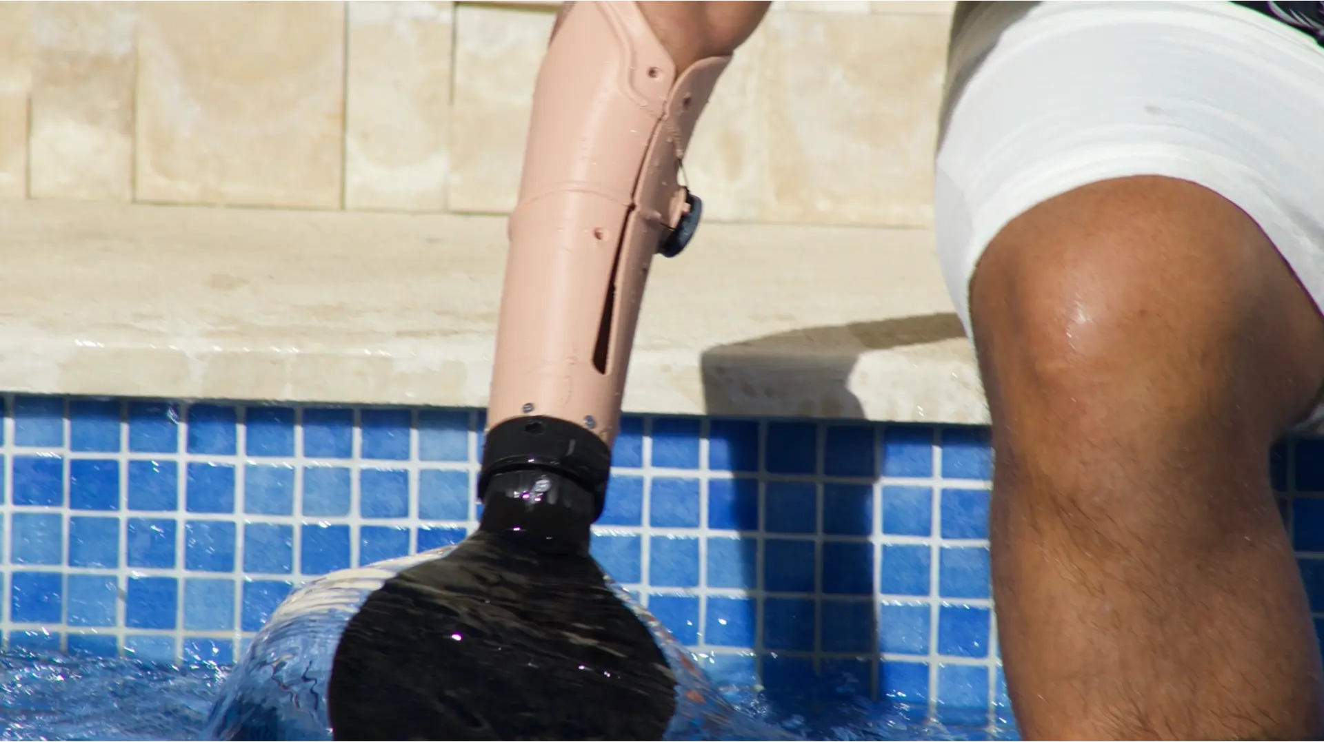 Flow passive prosthetic arm in a skin-tone finish at the edge of a swimming pool